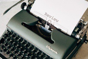 A typewriter with a book review being typed on a piece of paper.