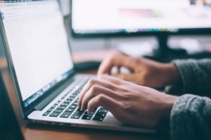 Author sitting at a computer creating a book proposal to promote a book.