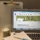A notepad and pen are placed alongside a laptop, opened to Smith Publicity's LinkedIn page. There is a matching green candle next to the laptop.